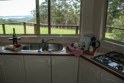Awaken's kitchen has windows behind the sink with a panoramic view over Wilson Inlet, Nullaki Penninsula and the Southern Ocean.